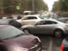 Парализованный светофор вынудил водителей лично регулировать движение машин под дождем в Ростове