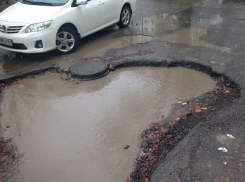 Огромная яма на улице Ростова стремительно увеличилась и грозит поглотить весь город