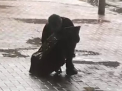 Странный мужчина с зонтом «приснул» посреди улицы в Ростове и попал на видео