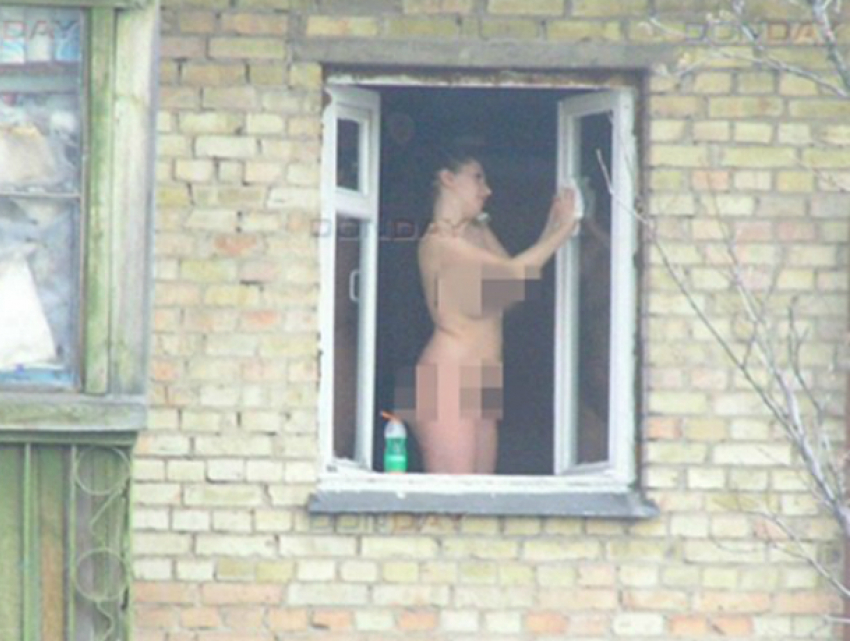 Голая женщина выходит с дома на улице, показывая своё тело